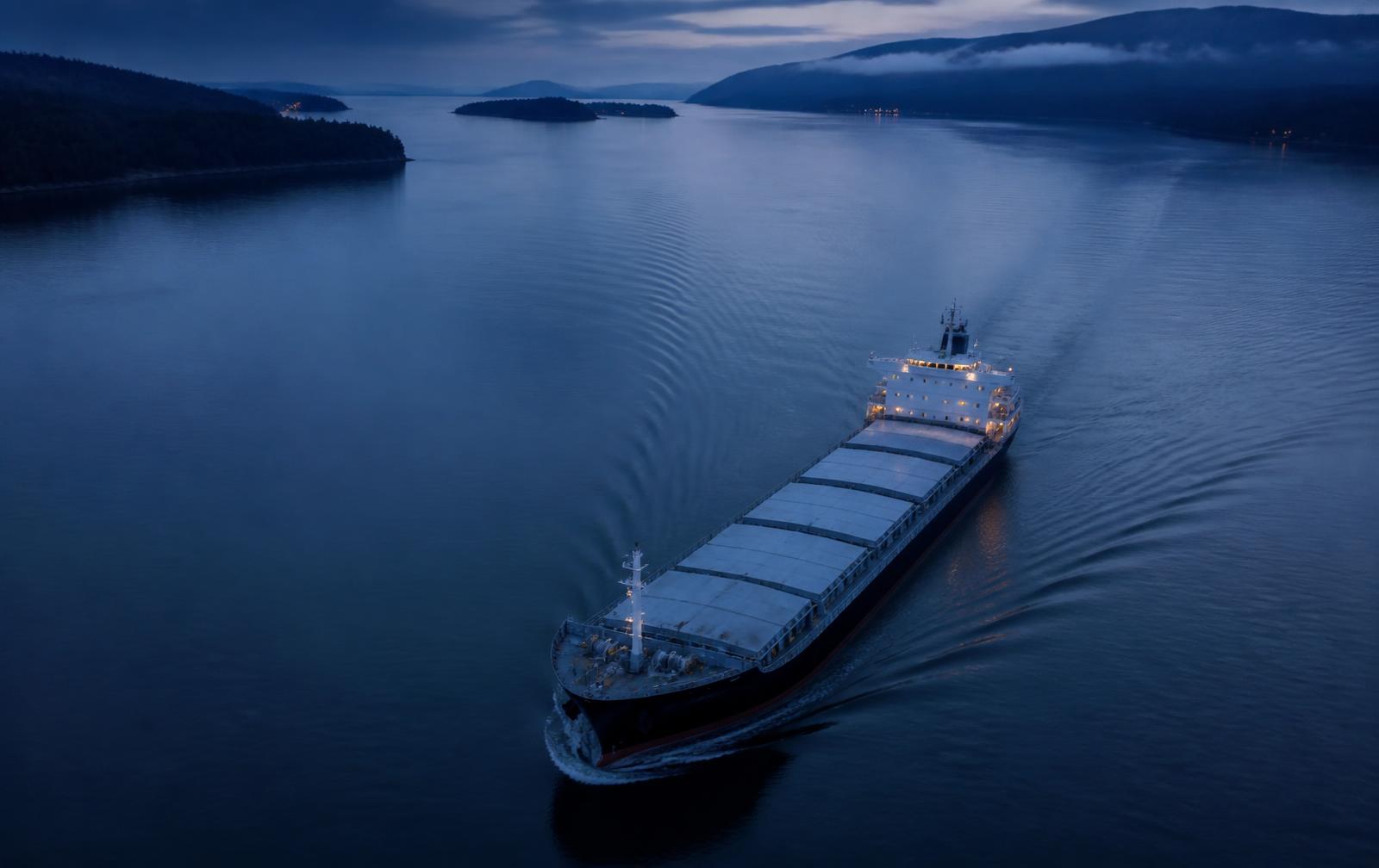 Navire commercial progressant sur une voie navigable calme à l'heure bleue (image représentative)